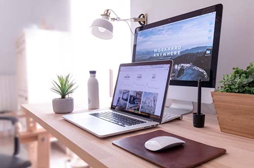 MacBook Pro on table beside white iMac and Magic M.jpg