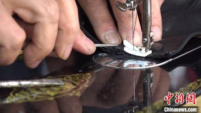 图为张怀友使用老式缝纫机缝补服装。　蒲文思 摄